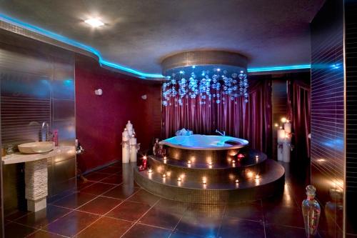 a bathroom with a tub and a shower with lights at Chaika Beach Resort in Sunny Beach