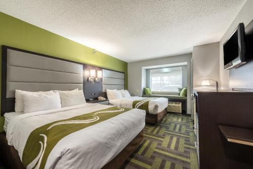 a hotel room with two beds and a television at Quality Inn Grove City - Columbus South in Grove City