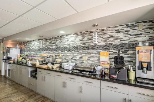 a kitchen with white cabinets and a brick wall at Quality Inn Grove City - Columbus South in Grove City