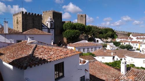 Blick auf eine Stadt mit Türmen und Dächern in der Unterkunft Casa da Talhada - Stone House in Óbidos