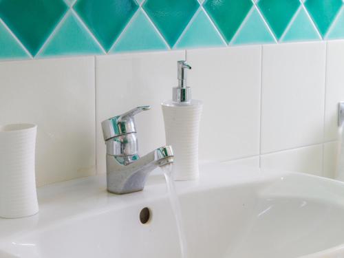 zlew w łazience z kranem i dwoma kubkami w obiekcie Gelso Bianco Apartments w mieście Campofelice di Roccella