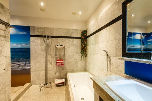a bathroom with a tub and a sink and a shower at Appartementhaus Freiler in Mörbisch am See