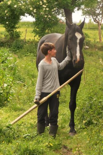 a woman standing next to a black and white horse at Studniska Country Estate in Studniska