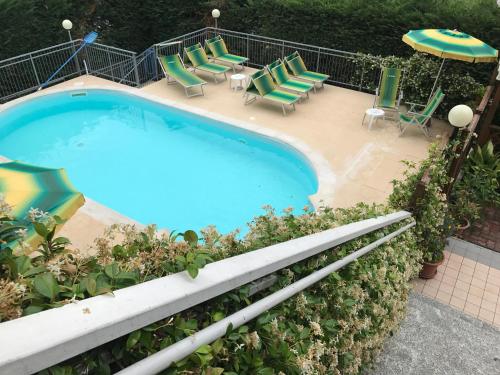 an overhead view of a swimming pool with chairs and an umbrella at Hotel Garden Ristorante in Tabiano
