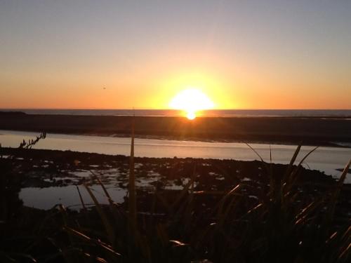 a sunset over a body of water with the sun setting at Lingalonga in Charleston