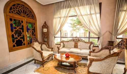 a living room with a couch and chairs and a table at Zalagh Parc Palace in Fès