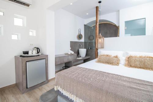 a white bedroom with a large bed and a sink at Malibu Boutique Studios & Bungalows in Faliraki