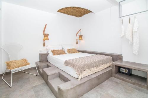 a bedroom with a bed and a chair at Malibu Boutique Studios & Bungalows in Faliraki