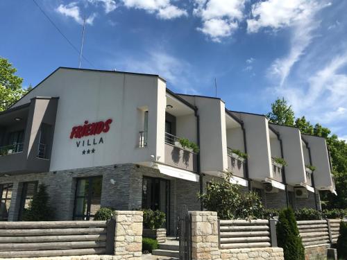 a building with a sign that reads interns villa at Family Hotel Friends Villa in Enchets