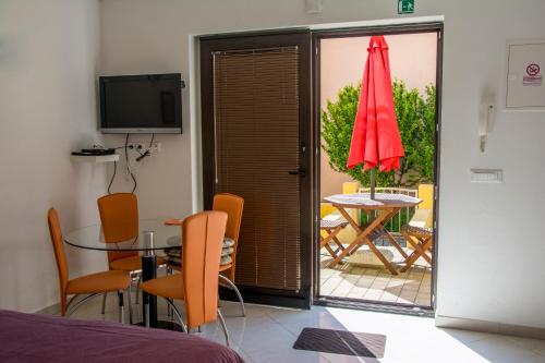 - une salle à manger avec une table et un parasol rouge dans l'établissement Villa Alpa, à Umag