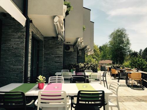 a group of tables and chairs on a patio at Family Hotel Friends Villa in Enchets