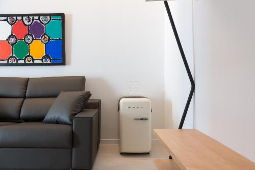 a living room with a couch and a small refrigerator at Sodium Boutique Hotel in Ciutadella