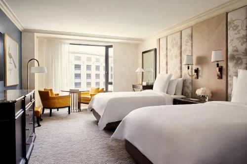 a hotel room with two beds and a living room at Four Seasons Boston in Boston