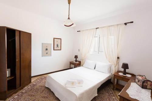 1 dormitorio con 1 cama blanca y TV en Villa Dimitra Gennadi, en Gennadi