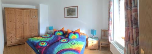 苏尔茨贝格Ferienwohnung Rottachseeblick in Moosbach的卧室里有一张床，床上铺着色彩鲜艳的被子