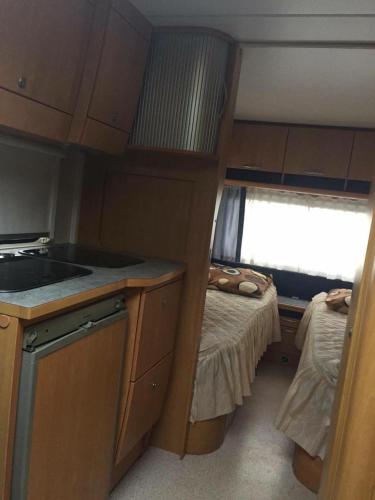 a small kitchen with a sink and a bed at Irjados-surf in Chałupy