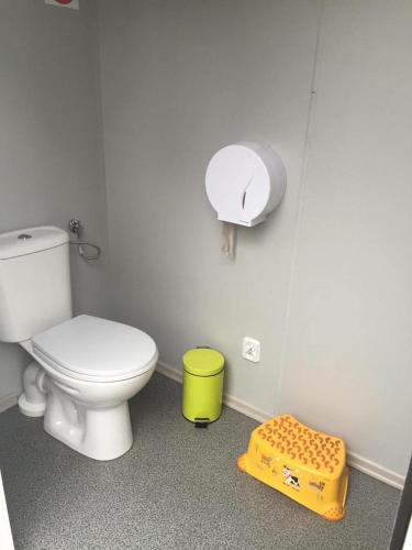a bathroom with a white toilet and a yellow container at Irjados-surf in Chałupy