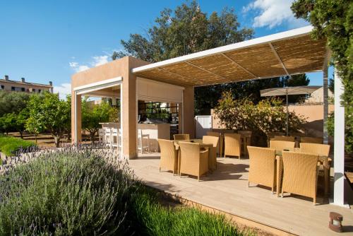 a patio with tables and chairs under a pavilion at Hotel Ca'n Bonico in Ses Salines