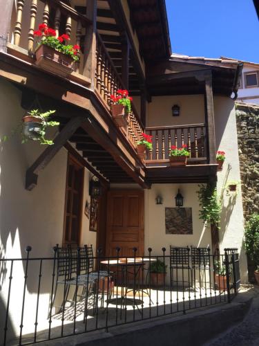 a building with a balcony with tables and chairs at Hostería La Antigua in Potes