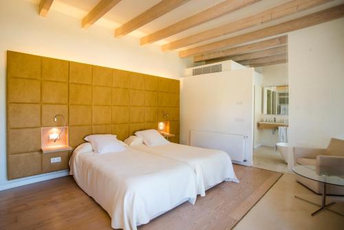 a bedroom with two beds and a table and a couch at Hotel Ca'n Bonico in Ses Salines