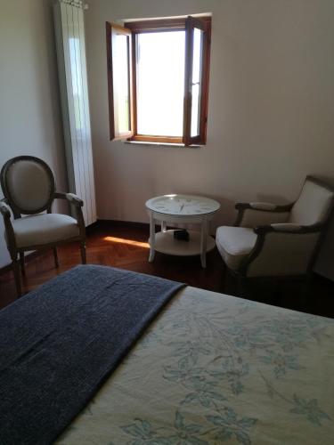a bedroom with a bed and chairs and a table at Il Silos in Maccarese