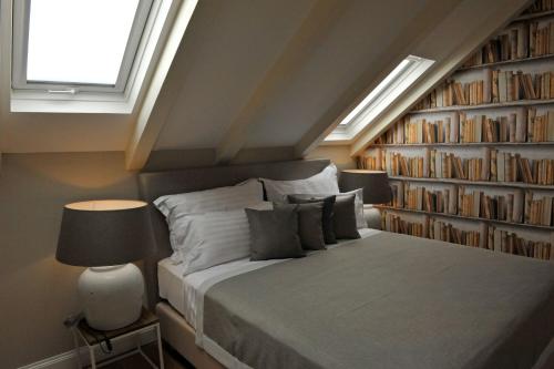ein Schlafzimmer mit einem Bett und einem Bücherregal mit Büchern in der Unterkunft Bajamonti 5 Luxury Rooms in Split
