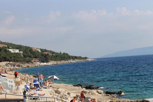 a group of people on a beach near the water at Apartments Mareblu in Rabac