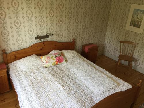 a bedroom with a wooden bed with a white comforter at Silte Siglajvs 147 in Havdhem