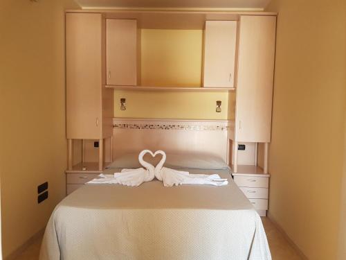 a bed with a heart shaped towel on it at La Rosa dei Venti in Zambrone