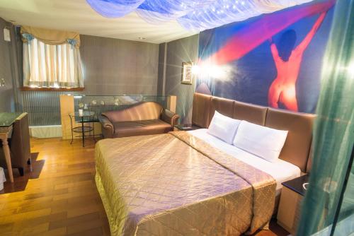 a bedroom with a bed and a chair at 亞歷山大汽車旅館 in Kaohsiung