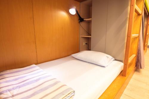 a small bedroom with a bed and bunk beds at On My Way - Taipei Hostel in Taipei