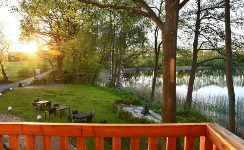 a park with tables and chairs next to a lake at Seehaus Hartwigsdorf in Klein Vielen