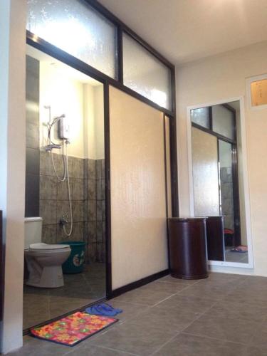 a bathroom with a toilet and a sliding glass door at Brown Epitome Lodge in Baler