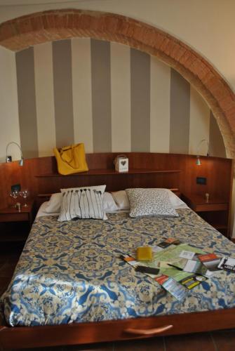 シエナにあるAppartamento I 2 Archiのベッドルーム1室(ストライプの壁のベッド1台付)