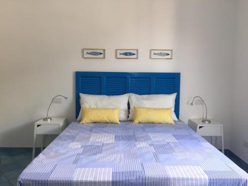 a bed with a blue headboard in a bedroom at Casa Sole in Minori