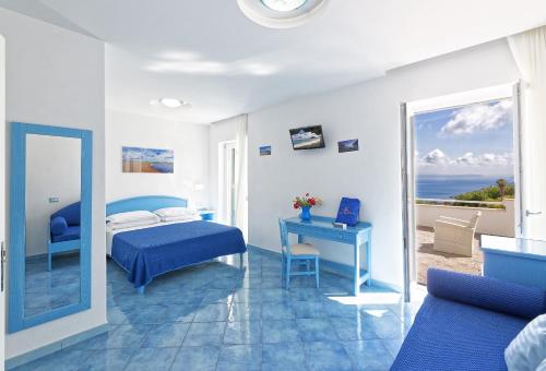 a bedroom with a bed and a desk and a window at Hotel Villa D'Orta in Ischia