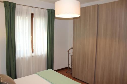 a bedroom with a bed and a large window at Casa "La Valle dei Segni" in Piancogno