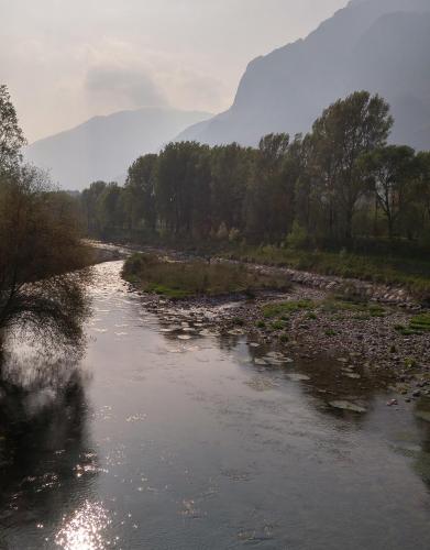 a river with rocks and a mountain in the background at Casa "La Valle dei Segni" in Piancogno