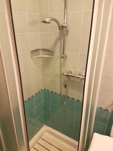a shower in a bathroom with green tiles at Hotel Residence Adriana in Cesenatico