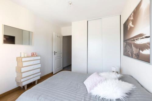 a white bedroom with a bed and a white cabinet at Sweet Apartment in Saint Malo