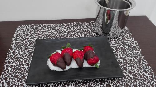 a chocolate dessert with strawberries on a black plate at B&B Vistamareblu in San Foca