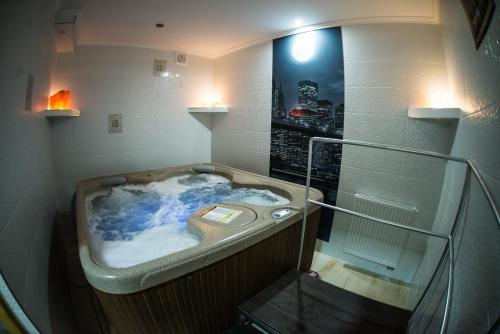 a jacuzzi tub with a picture of a city at Pensjonat Pod Kogutami in Bieliny