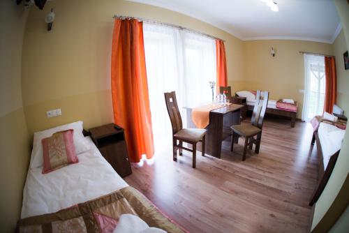 a bedroom with a table and a dining room at Pensjonat Pod Kogutami in Bieliny