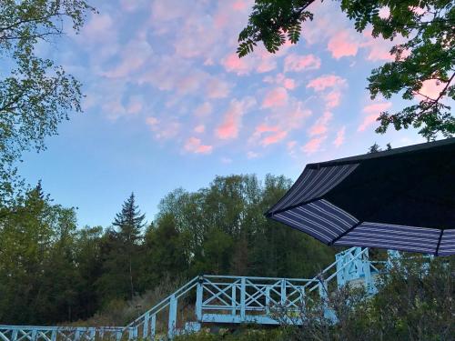 a white bridge with a blue sky and trees at Halcyon Heights B&B/Inn in Homer