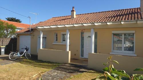 a bicycle parked in front of a house at Maison bord de mer in Saint-Hilaire-de-Riez