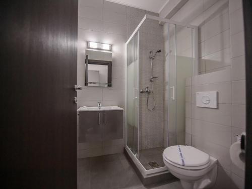 a bathroom with a shower and a toilet and a sink at Vila La Mer Mamaia Nord in Mamaia Nord