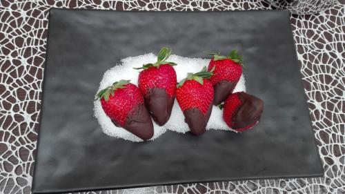 a group of strawberries in a plate of sugar at B&B Vistamareblu in San Foca