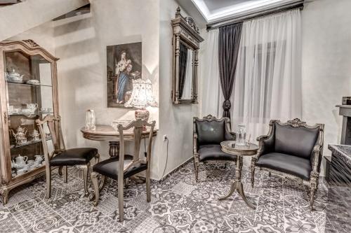 uma sala de jantar com cadeiras, uma mesa e um espelho em Anama Suite em Corfu Town