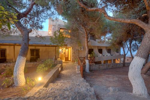 a house with trees in front of it at Hotel Abatis in Skala