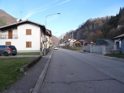 an empty street with a building and a car on the road at Hotel Galles in Paluzza